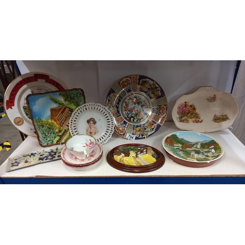 704 - A shelf of interesting collector's and other plates.