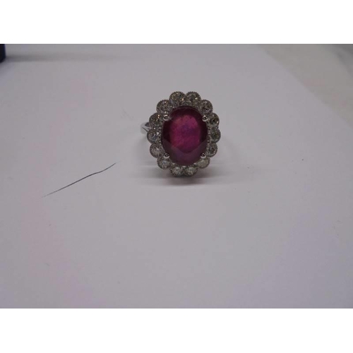 48 - A 6.5 carat oval ruby platinum and diamond ring, size N half, 8 grams.