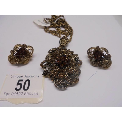 50 - A vintage ornate pendant with matching earrings.