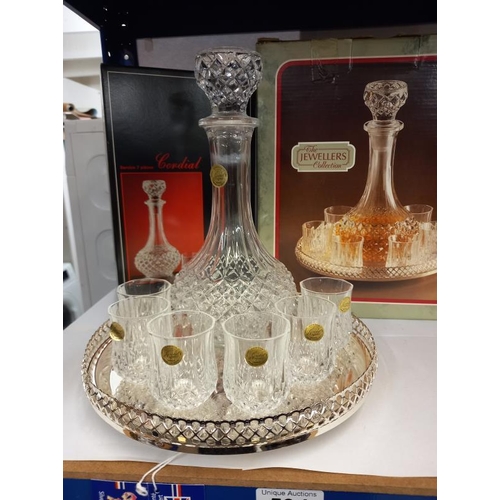 594 - A boxed crystal decanter with 6 glasses & a tray