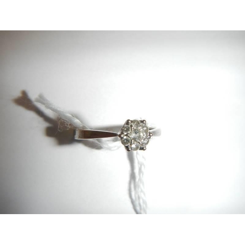 29 - A white gold floral diamond ring, size N half, 1.9 grams.