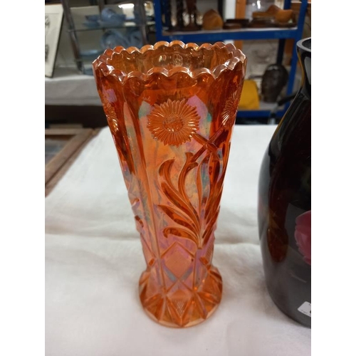 654 - A glass vase in black and decorated with roses together with a pale orange pressed glass vase.