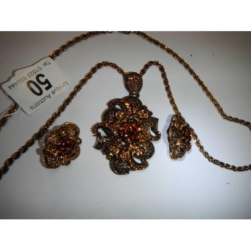 50 - A vintage ornate pendant with matching earrings.