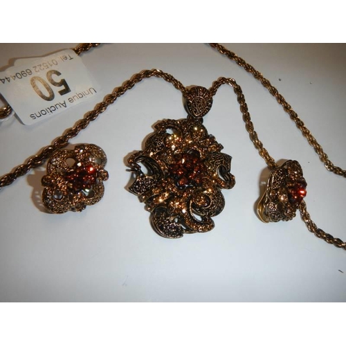 50 - A vintage ornate pendant with matching earrings.