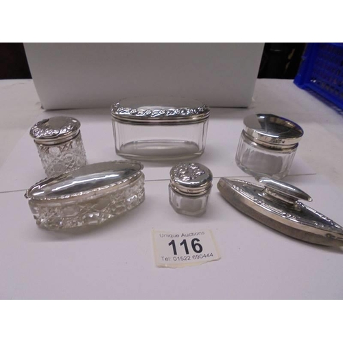 116 - Five assorted silver topped trinket pots and a silver nail polisher.