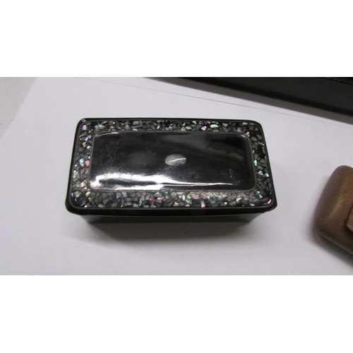 121 - A Japanese lacquered brush box, a lacquer and mother of pearl pill box and three other boxes.