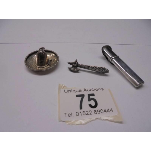 75 - A silver sombrero pendant, a silver axe brooch and a silver button hole holder 10 grams.