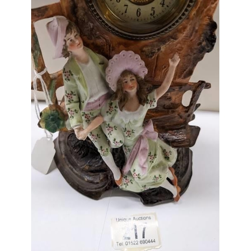 217 - A bisque porcelain mantel clock featuring a boy and girl.