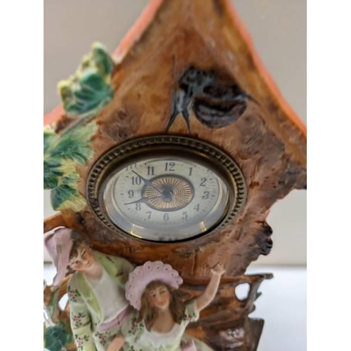 217 - A bisque porcelain mantel clock featuring a boy and girl.