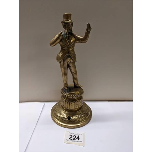 224 - A Victorian brass figure bar top mains gas lighter, 24 cm tall.