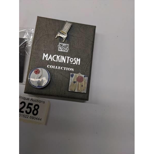 258 - Three enamel Mackintosh collection pin badges and a Marcel Brewer badge of a table.