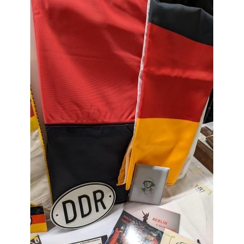 172 - A box of East German ephemera including flags, car badges, pin badges, medalliion and postcards.