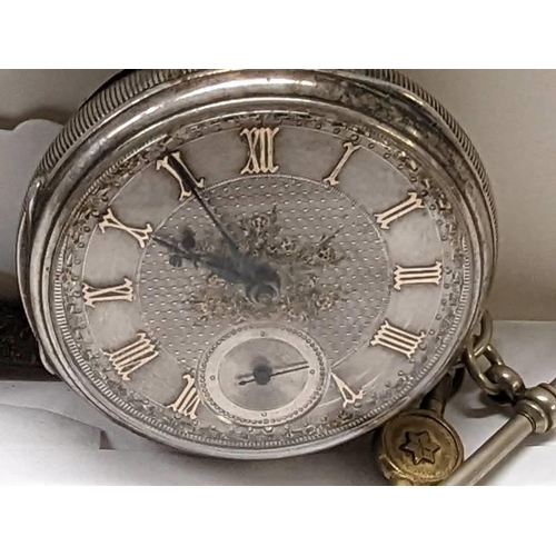 184 - A silver pocket watch with silver dial and Roman numerals.