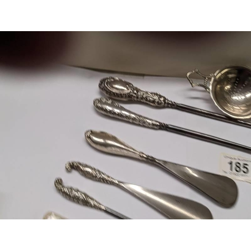 185 - A mixed lot of shoe horns, button hooks etc., some with silver handles, and a plated tea strainer.