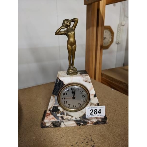 284 - An art deco marble mantel clock surmounted figure, base 13 x 4.5 cm, height 19.5 cm.