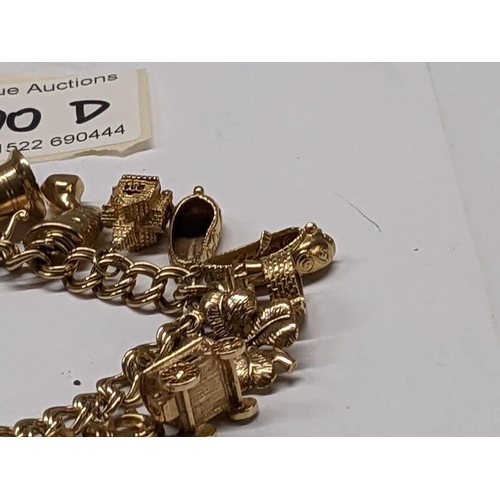 100D - A 9ct gold charm bracelet with 15 charms, in good condition, 41 grams.