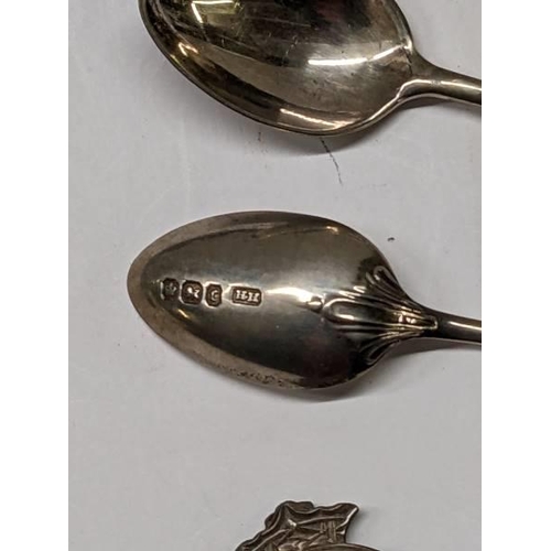 100L - Six silver spoons, a silver badge and one other silver item 54.5 grams.