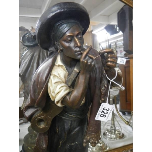 326 - A French spelter statue of  a man with a guitar smoking a cigarette.