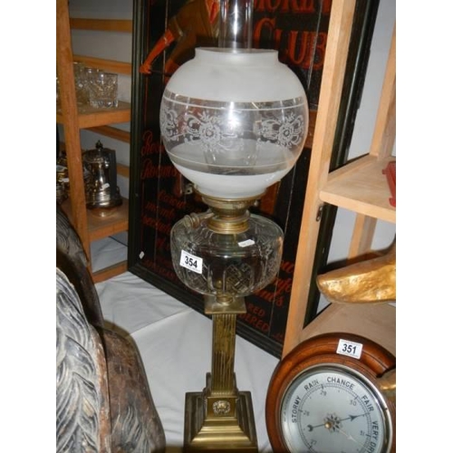 354 - A Victorian oil lamp with brass column, glass font and later shade.