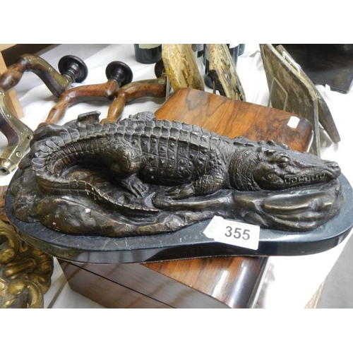 355 - A bronze sleeping crocodile on a marble base.