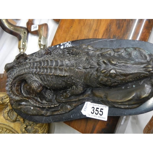 355 - A bronze sleeping crocodile on a marble base.