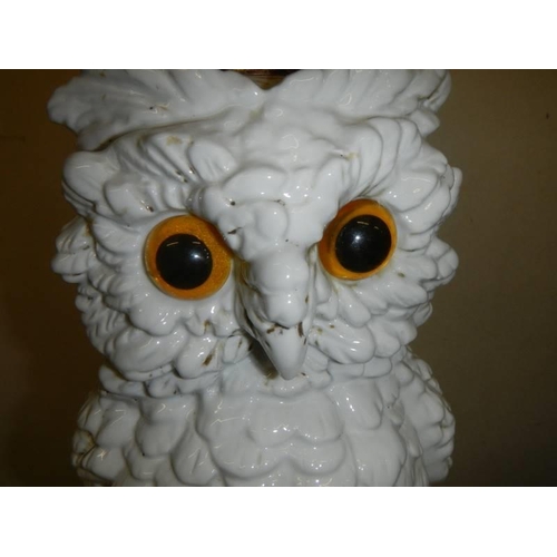 439 - A ceramic oil lamp in the form of an owl with crossed swords mark.