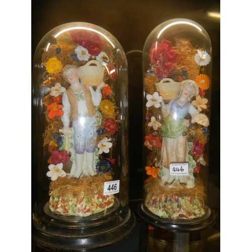 446 - A pair of 19th century bisque porcelain figures under unrelated glass domes.