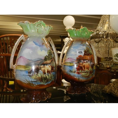 456 - A pair of Staffordshire vases hand painted with cattle.