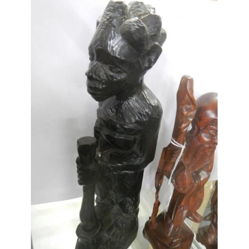 465 - Three carved wood figures and a mask.