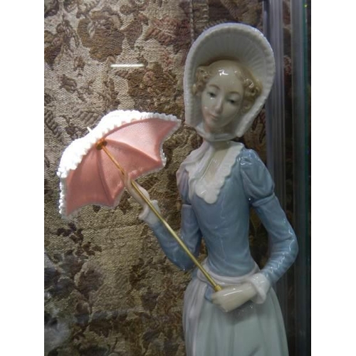 525 - A Lladro figure of a lady with parasol.