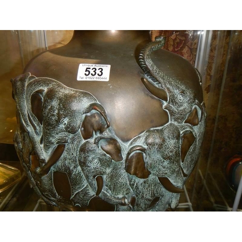 533 - A 19th century heavy bronze urn featuring elephants.