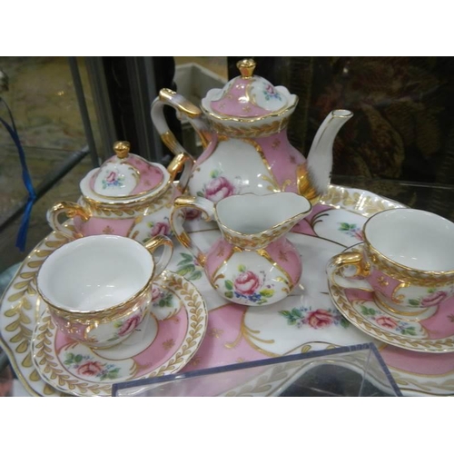 535 - A miniature tea set and one other.