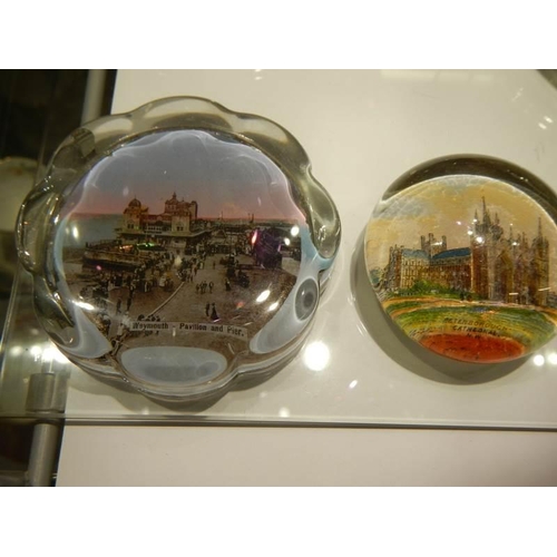 538 - A small collection of souvenir paperweights with various scenes, eleven in total.