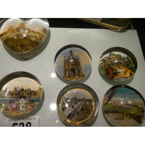 538 - A small collection of souvenir paperweights with various scenes, eleven in total.