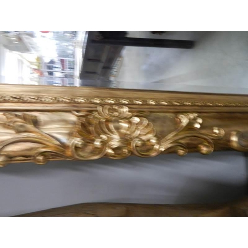 650 - A large rectangular bevel edged mirror in gilded swept frame. 88 x 175 cm.