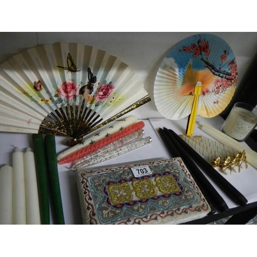 703 - An oriental fabric covered box, 2 fans and a quantity of candles.