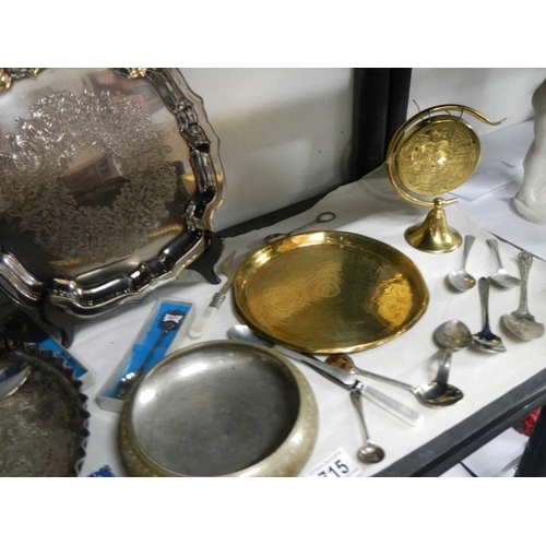 715 - A mixed lot of brass and silver plate including brass gong, spoons etc.,