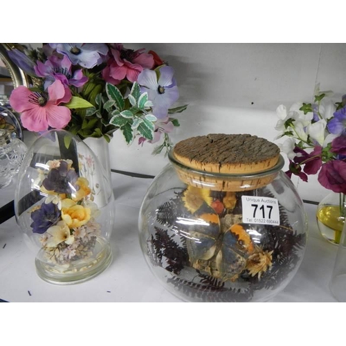 717 - Two floral diorama's under glass, two plastic clock domes and artificial flowers.