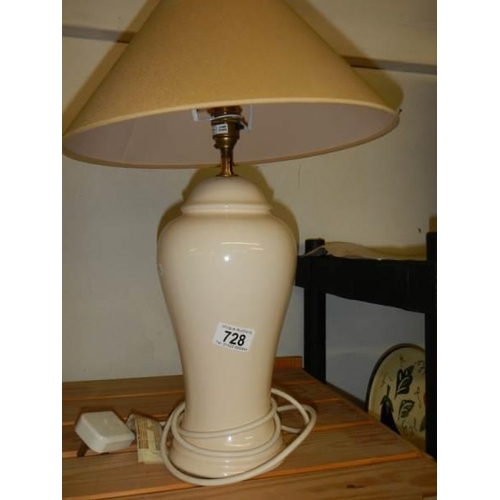 728 - A pair of cream pottery table lamps with shades, height 62 cm.