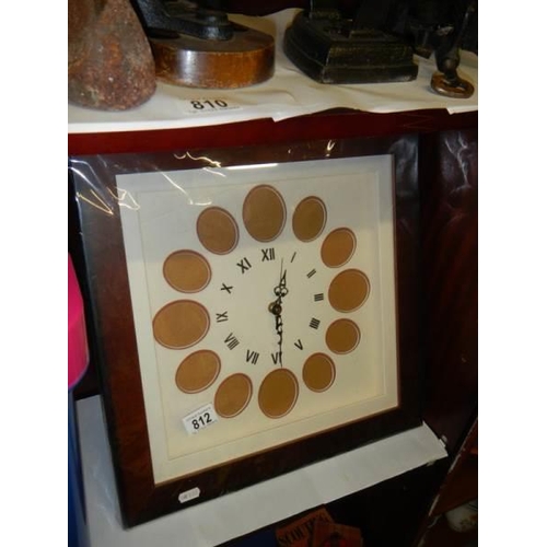 812 - A photo frame wall clock with 12 spaces.