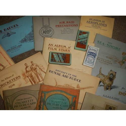 885 - A mixed lot of cigarette card albums with contents including RAF badges, air raid precautions etc.,