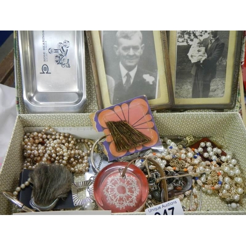 947 - A box of costume jewellery, Edwardian photo frames etc.,