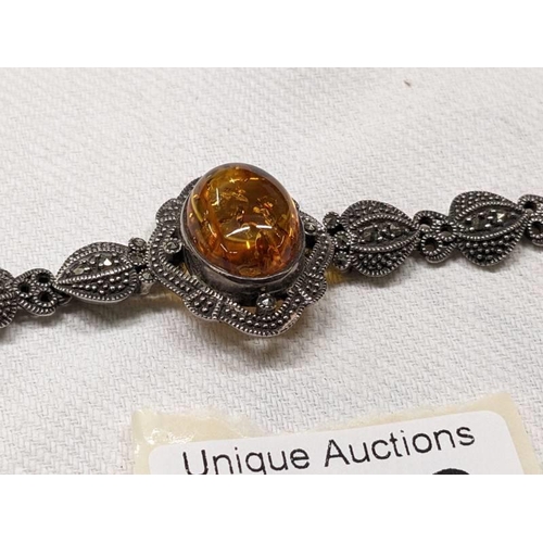 1018 - A silver marcasite bracelet set central amber stone.