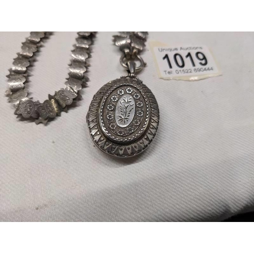 1019 - A Victorian silver locket on a decorative un-marked chain.