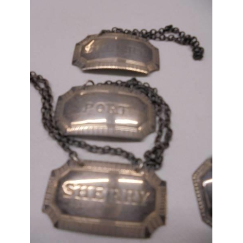 1026 - Three silver wine labels on metal chains (18g without chains), an unmarked claret label and a small ... 