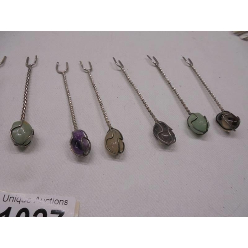 1027 - Eleven cocktail forks with semi precious stone tops.