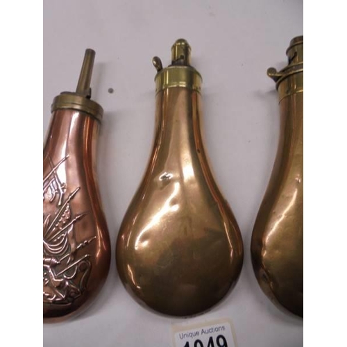 1049 - Three Victorian copper gun powder flasks.