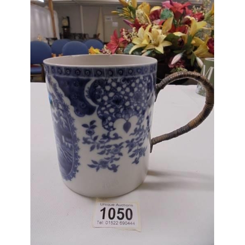 1050 - An early 20th century blue and white tankard with cane handle (a/f chips to top rim).