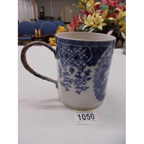 1050 - An early 20th century blue and white tankard with cane handle (a/f chips to top rim).