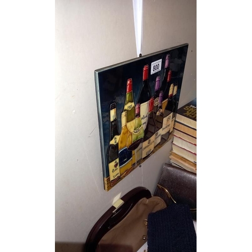 800 - A large hand painted tile/plaque with back stand and hook featuring bottles of wine